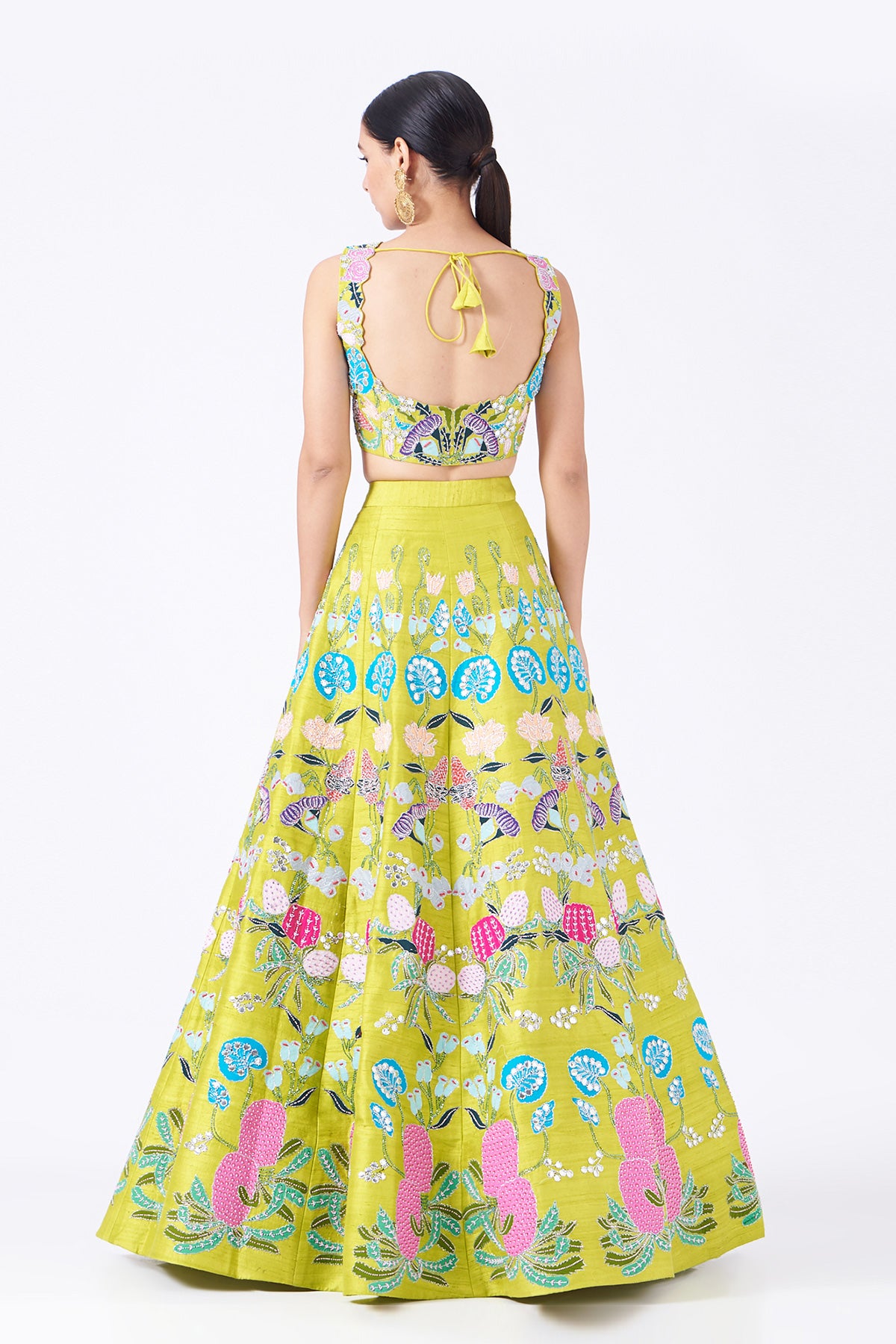 Back view of lime raw silk appliquéd lehenga with blouse and cutwork dupatta