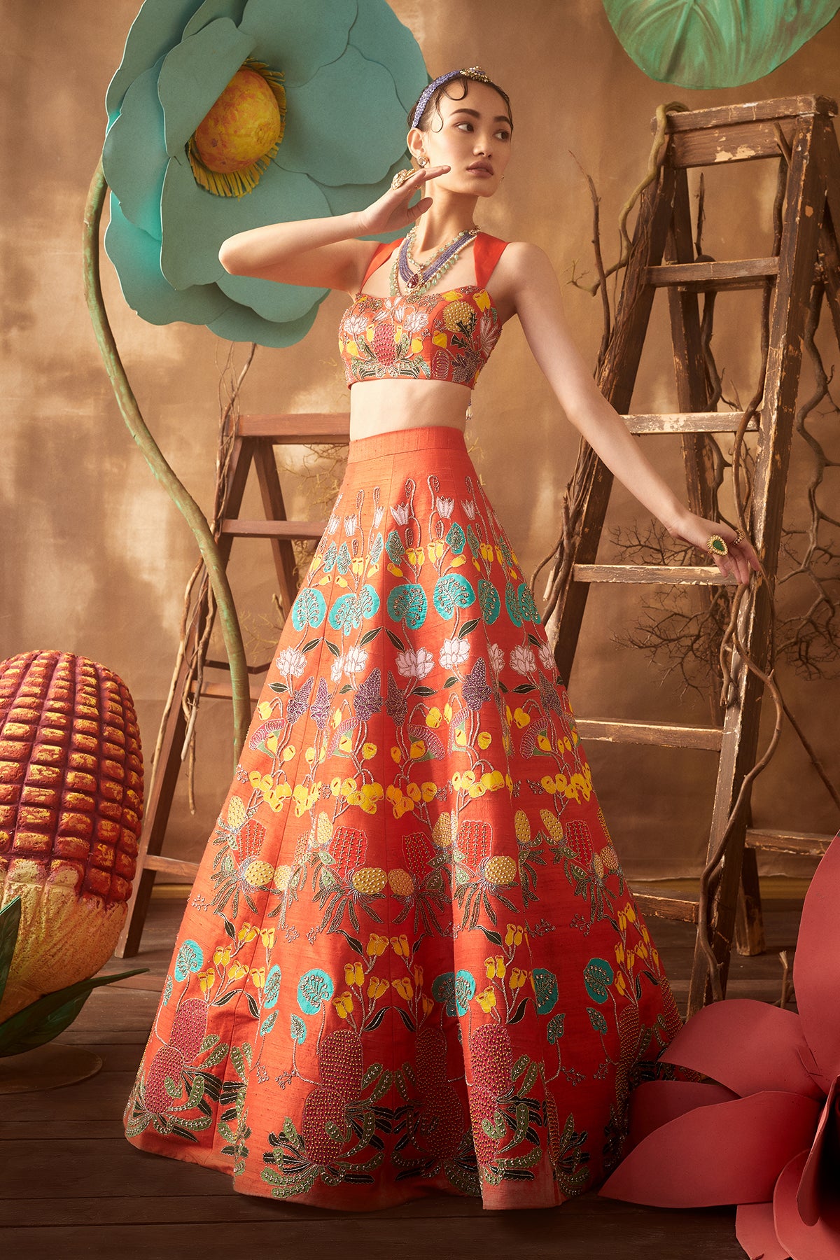 Left side view of orange pastiche raw silk appliquéd lehenga with blouse and cutwork dupatta